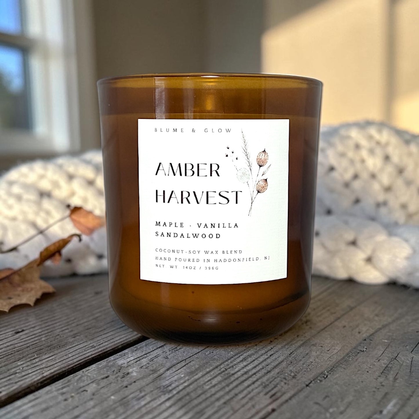 Amber Harvest candle styled with cozy fall décor, creating a warm autumn atmosphere.