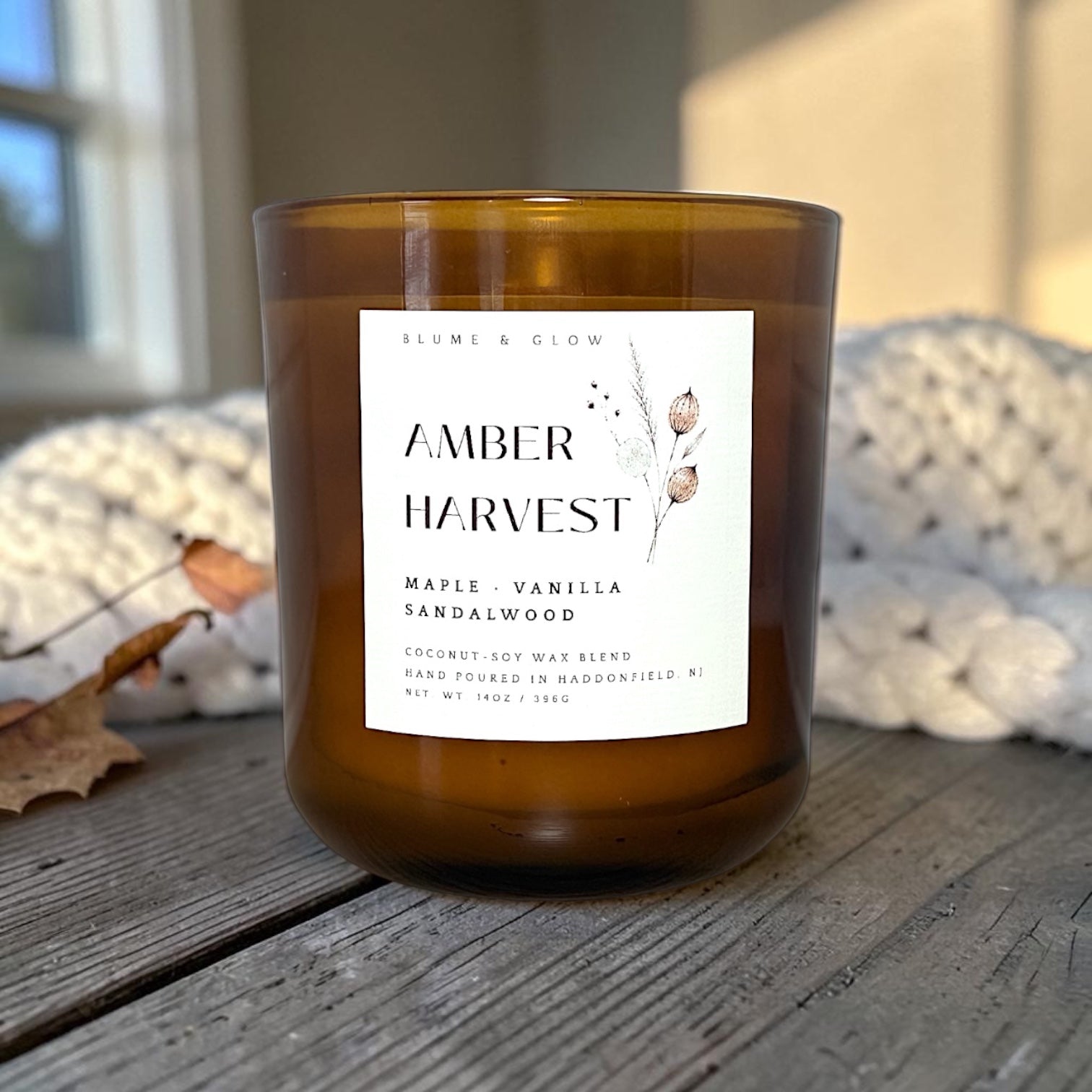 Amber Harvest candle styled with cozy fall décor, creating a warm autumn atmosphere.
