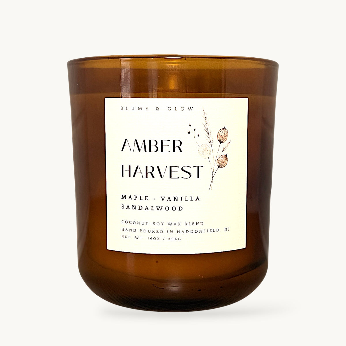 Amber Harvest maple cinnamon and vanilla autumn candle by Blume & Glow with wooden wick in a translucent amber jar