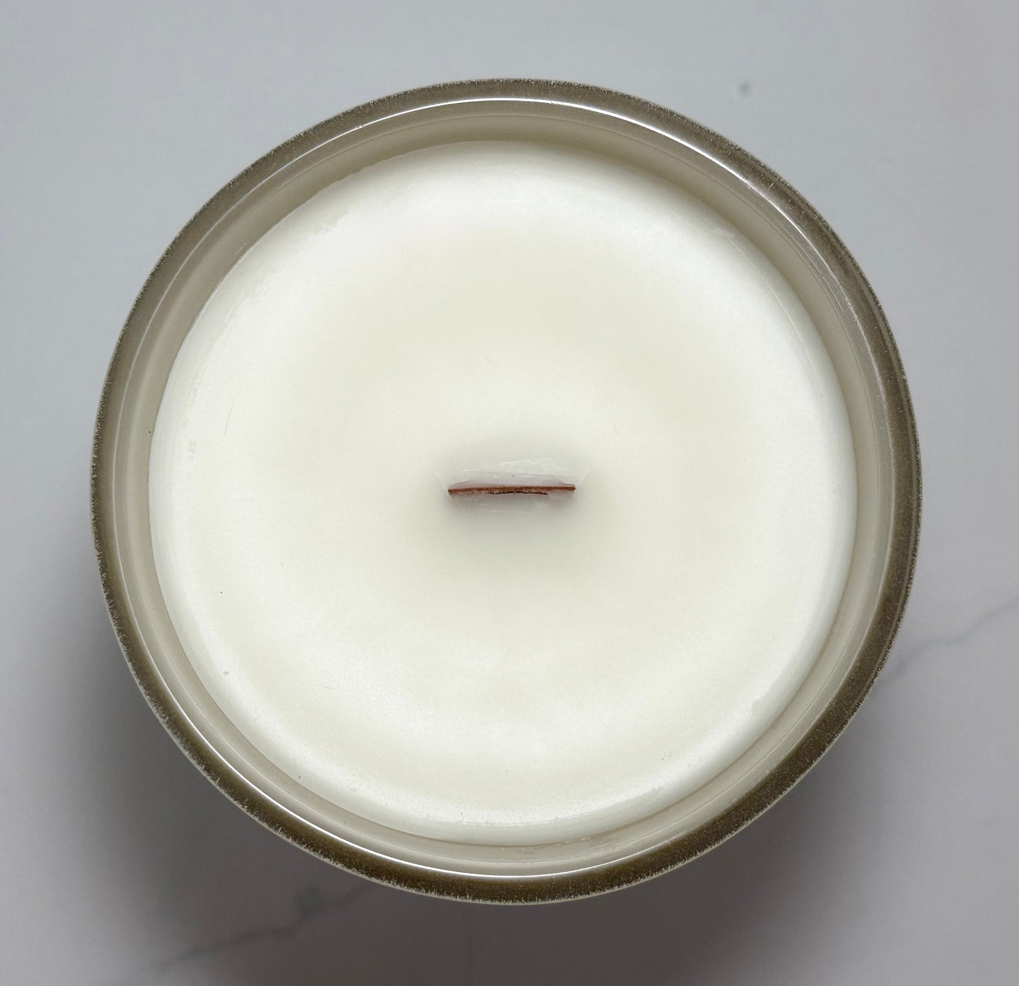 Top view of the Cozy Season candle featuring a natural wooden wick and creamy coconut-soy wax.