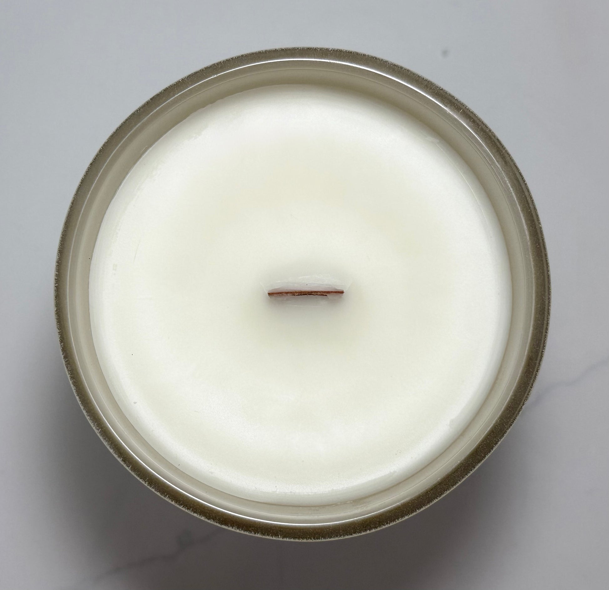Top view of the Cozy Season candle featuring a natural wooden wick and creamy coconut-soy wax.