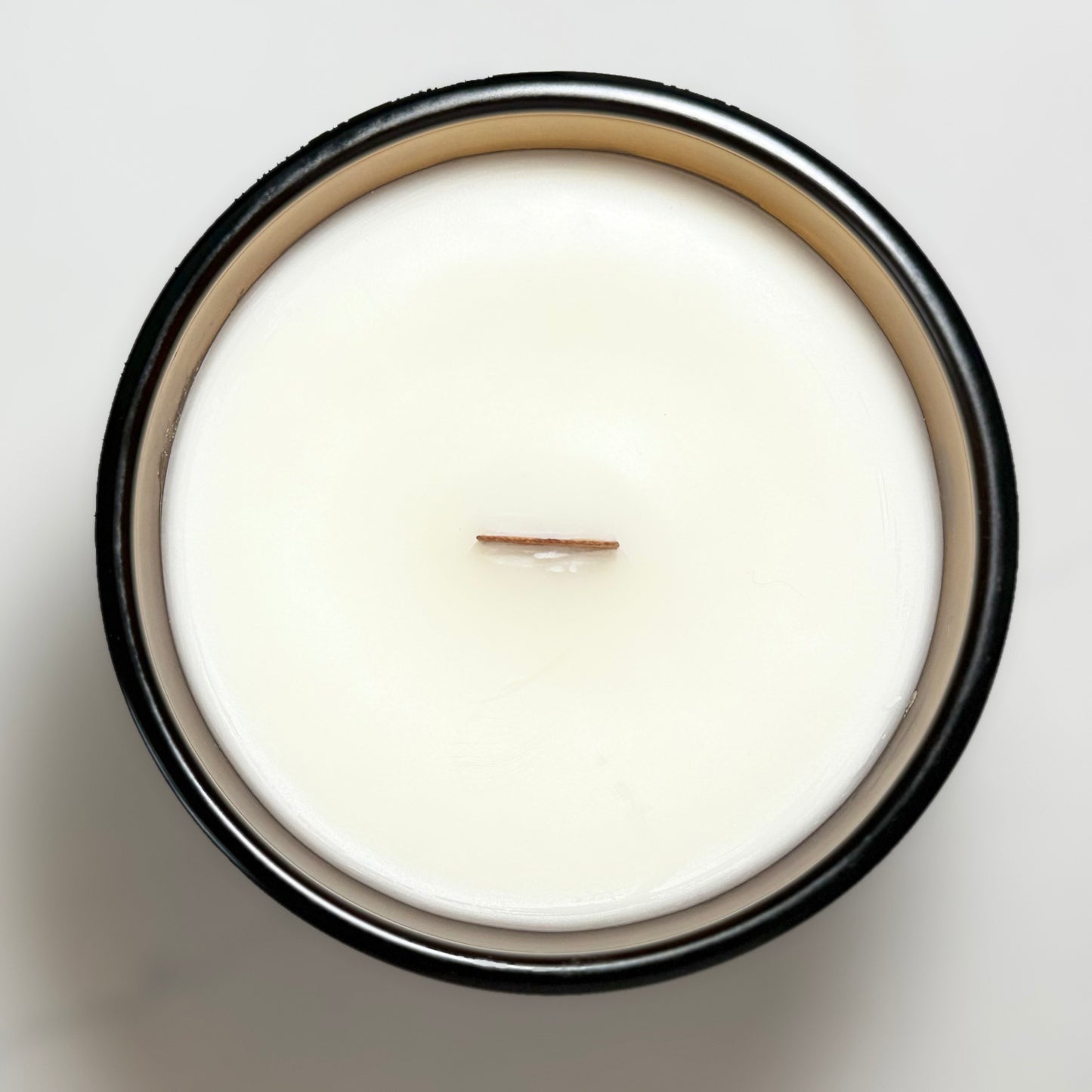 Top view of the Cozy Crumble candle featuring a natural wooden wick and creamy coconut-soy wax.