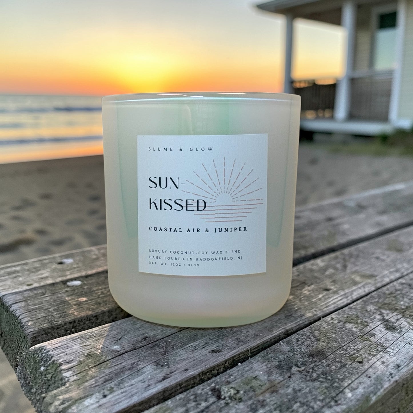 Sun Kissed coastal candle by Blume & Glow burning on a beach-inspired setting, bergamot sea salt and peony fragrance