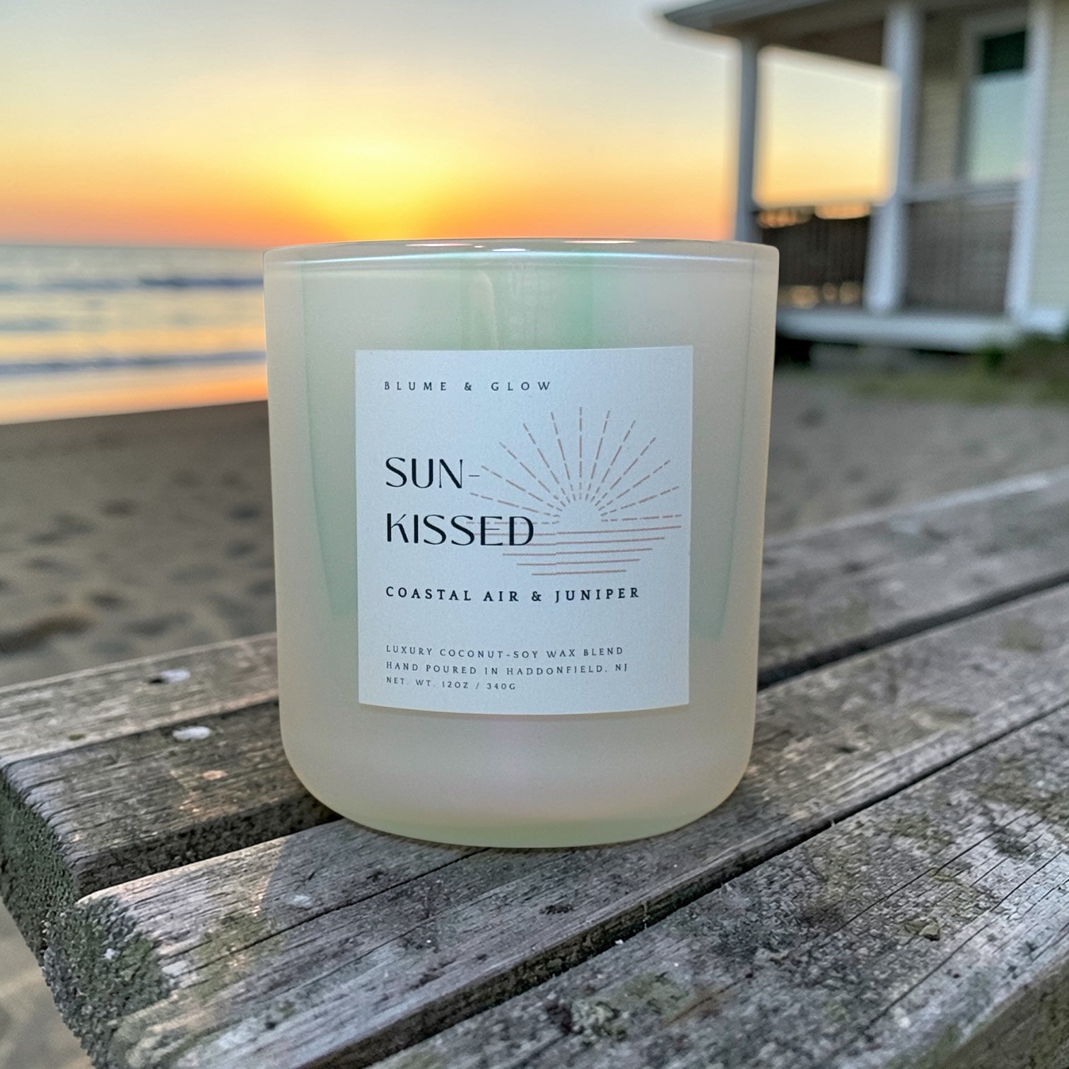Sun Kissed coastal candle by Blume & Glow burning on a beach-inspired setting, bergamot sea salt and peony fragrance