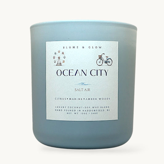 Ocean City NJ inspired candle by Blume & Glow with fresh coastal citrus scent, wooden wick, and coconut-soy wax in a matte blue jar 