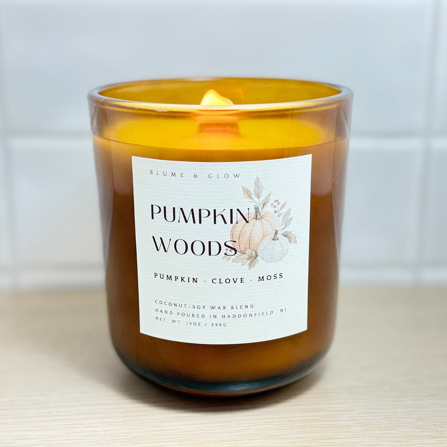 Pumpkin Woods candle burning with warm Pumpkin Woods and clove fragrance in a cozy home
