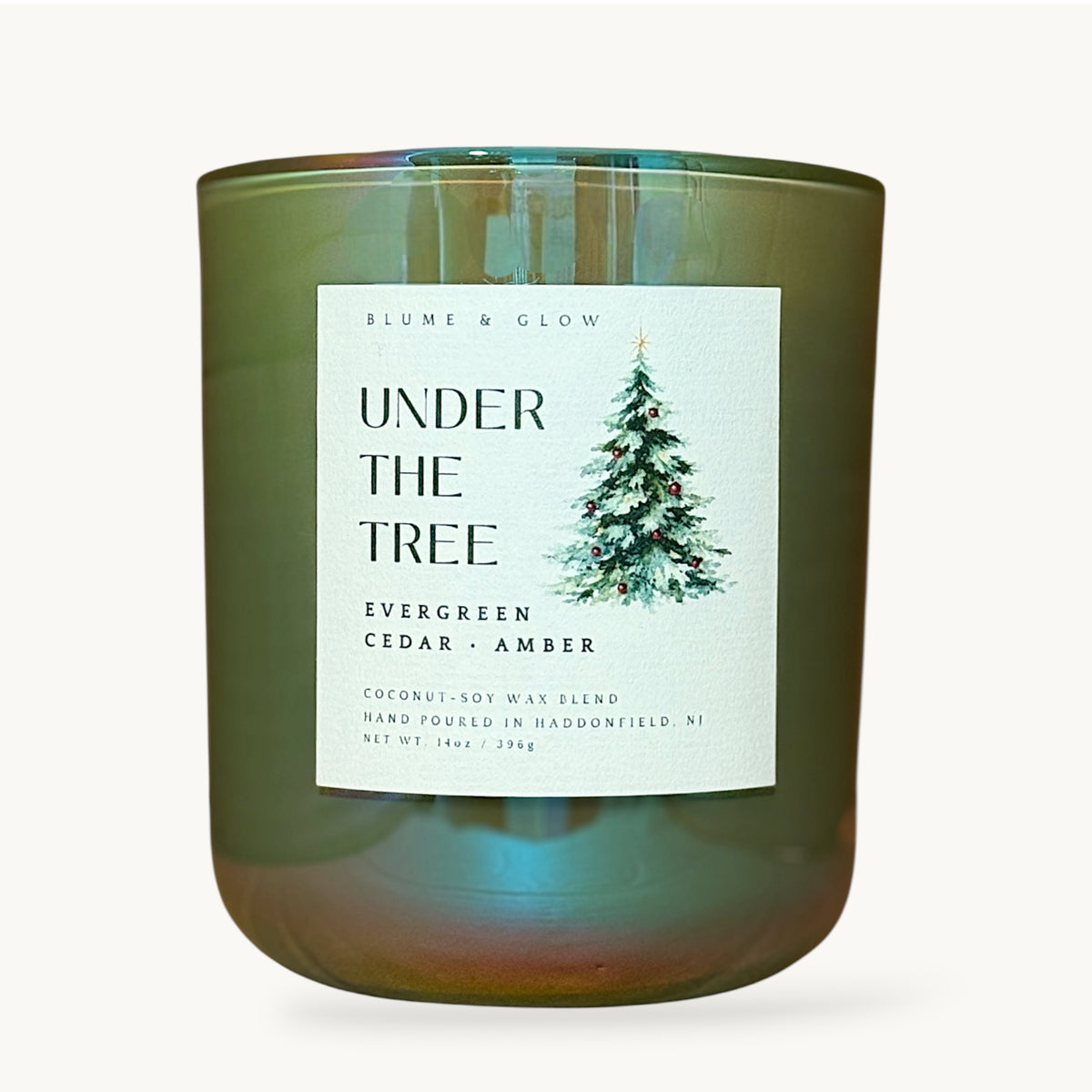 Under the Tree evergreen cedar and amber Christmas candle by Blume & Glow with wooden wick and coconut-soy wax blend in an iridescent green vessel